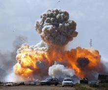 Vehicles belonging to forces loyal to Libyan leader Muammar Gaddafi explode after an air strike by coalition forces, along a road between Benghazi and Ajdabiyah, March 20, 2011. PHOTO BY REUTERS/Goran Tomasevic