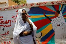 Alaa Salah, a Sudanese protester whose video went viral and made her an icon for the mass anti-government protests, stands in front of a mural depicting her near the defence ministry in Khartoum, Sudan, April 20, 2019. PHOTO BY REUTERS/Umit Bektas