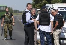 Alexander Hug (front C), deputy head for the Organisation for Security and Cooperation in Europe's (OSCE) monitoring mission in Ukraine, stands with members of his team on the way to the site in eastern Ukraine where the downed Malaysian airliner MH17 crashed, outside Donetsk