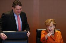 German Chancellor Angela Merkel (R) and Economy Minister Sigmar Gabriel arrive for the weekly cabinet meeting in Berlin