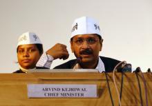 Arvind Kejriwal (R), leader of Aam Aadmi (Common Man) Party, speaks during a meeting with his party leaders and media personnel after taking the oath as the new chief minister of Delhi, in New Delhi