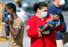 A Red Cross member carries a child as migrants disembark from the Italian Navy vessel Sfinge in the Sicilian harbour of Pozzallo, southern Italy, August 31, 2016. PHOTO BY REUTERS/Antonio Parrinello