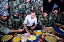 Syria's President Bashar al-Assad (C) joins Syrian army soldiers for Iftar in the farms of Marj al-Sultan village, eastern Ghouta in Damascus, Syria, in this handout picture provided by SANA, June 26, 2016. PHOTO BY REUTERS/SANA