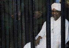 Sudan's former president Omar Hassan al-Bashir sits guarded inside a cage at the courthouse where he is facing corruption charges. PHOTO BY REUTERS/Mohamed Nureldin Abdallah