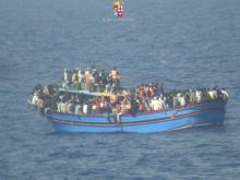 Migrants sit in their boat during a rescue operation by Italian navy ship Grecale (not pictured) off the coast of Sicily, in this handout picture by the Italian Marina Militare