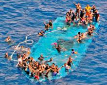 Migrants on a partially submerged boat before being rescued by Spanish fregate Reina Sofia (unseen) taking part in the European Union military operation in the Southern Central Mediterranean (EUNAVFOR MED) off the coast of Libya, May 26, 2016. PHOTO BY REUTERS/EUNAVFOR MED