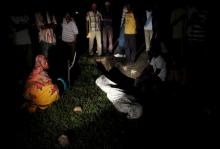 Relatives and friends gather around the covered body of Zedi Feruzi, the head of opposition party UPD, in Bujumbura, Burundi, May 23, 2015. PHOTO BY REUTERS/Goran Tomasevic 