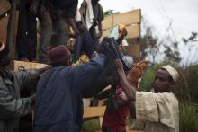 Men assist to carry the body of a dying from a gunshot wound to the head close to the village of Dekoua after the armed peacekeeping convoy from the African Union operation in CAR (MISCA) she was travelling in came under attack by anti Balaka militiamen