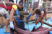 Yemeni fishermen carry the body of a Somali refugee, killed in attack by a helicopter while travelling in a vessel off Yemen, are pictured at the Red Sea port of Hodeidah, Yemen, March 17, 2017. PHOTO BY REUTERS/Abduljabbar Zeyad