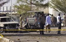 Bomb detection experts and members of the military stand at the scene of an explosion at a police station in Kano, November 15, 2014. PHOTO BY REUTERS/Stringer