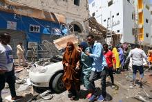 A Somali man evacuate women from the scene where a car bomb exploded at a shopping mall in Mogadishu, Somalia, February 4, 2019. PHOTO BY REUTERS/Feisal Omar