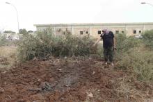 A member of the February 17th Brigade, points at the site of a bombing at the brigade's base after it was bombed by two jets in Benghazi