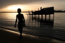 A Nigerian boy walks along the river bank at sunset in Ibeshe near Nigeria's commercial hub Lagos, May 24, 2006. PHOTO BY REUTERS/George Esiri