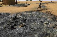 A boy walks past a house that was burned down during an attack by rebels in Mellit town in North Dar Four