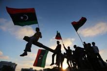 Boys, carrying flags, sit on a tank in Benghazi, March 19, 2014, during the third anniversary of an attack by pro-Gaddafi forces on Benghazi. PHOTO BY REUTERS/Esam Omran Al-Fetori