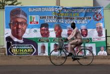 A cyclist drives pasts a campaign poster for President Muhammadu Buhari in a street after the postponement of the presidential election in Kano, Nigeria, February 17, 2019. PHOTO BY REUTERS/Luc Gnago