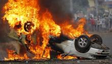 A car belonging to a policeman burns after protesters intercepted him at a barricade during demonstrations against the ruling CNDD-FDD party's decision to allow President Pierre Nkurunziza to run for a third five-year term in office, in Bujumbura, Burundi April 30, 2015. REUTERS/Thomas Mukoya