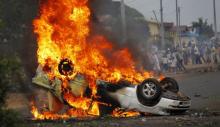 A car belonging to a policeman burns after protesters intercepted him at a barricade during demonstrations against the ruling CNDD-FDD party's decision to allow President Pierre Nkurunziza to run for a third five-year term in office, in Bujumbura, Burundi, April 30, 2015. PHOTO BY REUTERS/Thomas Mukoya