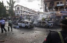 Burnt-out cars are seen at the scene of a blast in Abuja