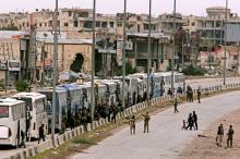 Syrian forces of President Bashar al Assad are seen around buses carry civilian and rebels outside Harasta in eastern Ghouta in Damascus, Syria, March 23, 2018. PHOTO BY REUTERS/ Omar Sanadiki