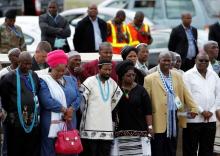 AbaThembu King Buyelekhaya Dalindyebo (3rd L) looks on with some members of his family as former South African President Nelson Mandela's flag-draped coffin arrives at the Mthatha airport, in the Eastern Cape province, 900 km (559 miles) south of Johannesburg for a funeral on Sunday at his ancestral home in Qunu, December 14, 2013. PHOTO BY REUTERS/Siphiwe Sibeko