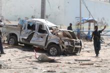 A policeman gives instructions near the wreckage of a car destroyed during a suicide bombing near the African Union's main peacekeeping base in Mogadishu, Somalia, July 26, 2016. PHOTO BY REUTERS/Ismail Taxta