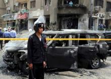 Policemen investigate the scene of a car bomb attack on the convoy of Egyptian public prosecutor Hisham Barakat near his house at Heliopolis district in Cairo, Egypt, in this June 29, 2015 file photo. PHOTO BY REUTERS/Mohamed Abd El Ghany