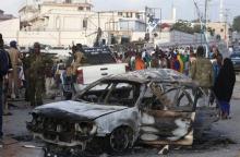 A car suspected by the Somali police to have been used in a bomb attack is seen as residents gather to view the damage at the scene of the attack near Somali Youth League Hotel, known as SYL hotel, in Hamarweyne district in Mogadishu, February 27, 2016. PHOTO BY REUTERS/Feisal Omar