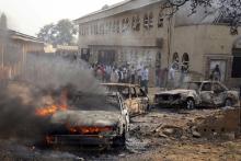 A car burns at the scene of a Christmas Day bomb explosion that the Islamist militant group Boko Haram claimed responsibility for at St. Theresa Catholic Church at Madalla, Suleja, just outside Nigeria's capital Abuja