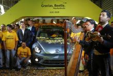 Employees pose for a picture next to a Volkswagen Beetle car during a ceremony marking the end of production of VW Beetle cars, at company's assembly plant in Puebla, Mexico, July 10, 2019. PHOTO BY REUTERS/Imelda Medina