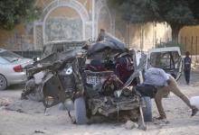 A Somali police officer looks inside the wreckage of a car destroyed when Islamist militants opened fire on government officials in a car and then a car bomb exploded, according to police and a spokesman for Mogadishu's mayor, in Yaqshiid district of Somalia's capital Mogadishu, April 18, 2016. PHOTO BY REUTERS/Feisal Omar