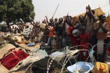 People gesture as they celebrate the resignation of Central African Republic's interim President Michel Djotodia at Bangui airport camp