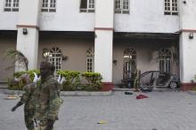 Chadian soldiers walk in front of a building that Boko Haram insurgents used as their base before being driven out by the Chadian military in Dikwa, March 2, 2015. PHOTO BY REUTERS/Madjiasra Nako 