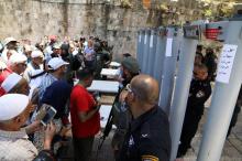 Palestinians stand in front of Israeli police officers and newly installed metal detectors at an entrance to the compound known to Muslims as Noble Sanctuary and to Jews as Temple Mount, in Jerusalem's Old City, July 16, 2017. PHOTO BY REUTERS/Ammar Awad