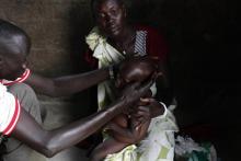 A medical staff attends to a severely malnourished child at the Medecins Sans Frontieres (Doctors Without Borders, MSF) feeding centre in Leer, Unity State