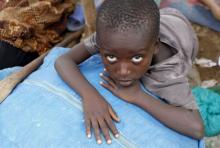 A Burundian refugee child rests on their belongings on the shores of Lake Tanganyika in Kagunga village in Kigoma region in western Tanzania, as they wait for MV Liemba to transport them to Kigoma township, May 18, 2015. PHOTO BY REUTERS/Thomas Mukoya