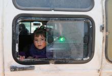 A child looks out of a window as Syrian refugees prepare to return to Syria from the Lebanese border town of Arsal, Lebanon, June 28, 2018. PHOTO BY REUTERS/Mohamed Azakir