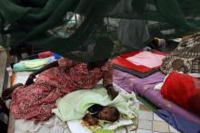 A malnourished two-month-old child lies on the bed next to his mother at a Medecins Sans Frontieres (MSF) hospital in an internally displaced persons (IDP) camp inside the U.N. base in Malakal, July 24, 2014. PHOTO BY REUTERS/Andreea Campeanu