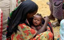 A woman holds her child as they wait to receive supplementary food at a distribution centre in Gelcha village, one of the drought stricken areas of Oromia region, in Ethiopia, April 28, 2016. PHOTO BY REUTERS/Tiksa Negeri