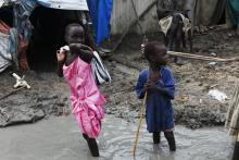 Children walk through mud in the internally displaced persons (IDP) camp inside the United Nations base in Malakal