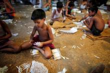 Children fill up empty cigarettes manually with locally grown tobacco in a small bidi (cigarette) factory at Haragach in Rangpur district, Bangladesh, July 11, 2013. PHOTO BY REUTERS/Andrew Biraj