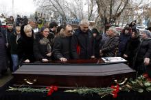 Relatives gather around the coffin of a victim of an explosion at a funeral in Volgograd