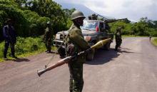 Congolese armed forces (FARDC) soldiers take position along a road as they advance while battling M23 rebels in Kibumba, north of Goma