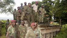 Congolese soldiers pose on a tank to celebrate their victory after taking over the headquarters of the M23 rebels at Rutshuru, north of Goma