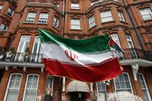 A voter holds a flag outside the Iranian consulate in central London