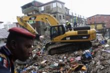 Rescuers operate an excavator at the site of a collapsed building, earlier marked for demolition, in Ebutte-Meta district in Lagos, July 11, 2013. PHOTO BY REUTERS/Akintunde Akinleye