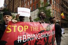 Demonstrators hold signs while chanting for the release of the Nigerian schoolgirls in Chibok who were kidnapped by Islamist militant group Boko Haram, outside of United Nations headquarters in New York