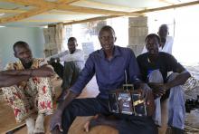 Men displaced by recent fighting in South Sudan listen to news on a radio in a makeshift camp inside the United Nations Mission in Sudan (UNAMIS) facility in Jabel, on the outskirts of capital Juba