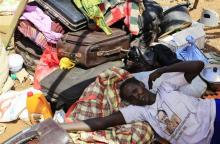 A mother displaced by recent fighting in South Sudan rests on top of her belongings inside a makeshift shelter at the United Nations Mission in Sudan (UNAMIS) facility in Jabel, on the outskirts of capital Juba