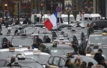 French striking taxi drivers block the traffic as they demonstrate at Porte Maillot in Paris during a national protest about competition from private car ride firms like Uber, France, January 26, 2016. PHOTO BY REUTERS/Charles Platiau